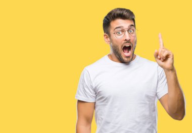 Başarılı fikirle izole arka plan işaret parmağı üzerinde gözlük takan yakışıklı delikanlı. Çıktıktan ve mutlu. Bir numara.