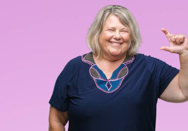 Beyaz kadın kıdemli artı boyutu izole arka plan gülümseyen ve süre seyir ve kamera boyutu işaret parmaklarıyla yapıyor el ile kendine güvenen el hareketi yüzünden. Ölçü kavramı.