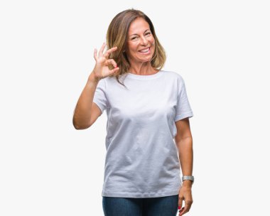 Gülümseyen izole arka plan üzerinde orta yaş İspanyol kadın kıdemli el ve parmaklar ok işaretiyle yapıyor olumlu. Başarılı ifade.