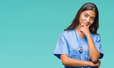 Genç Arap Doktor cerrah kadın izole arka plan emin çapraz kollar ve çeneme kaldırdı el ile gülümseme ile kameraya bakıyor. Pozitif düşünce.
