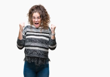 Güzel esmer kıvırcık saçlı Genç kız izole arka plan üzerinde kutluyor gözlük takan şaşırttı ve silah ile başarı için hayran kaldırdı ve gözleri açık. Kazanan kavramı.