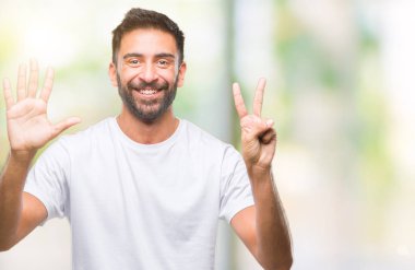 Gösterilen ve parmakları ile işaret izole arka plan yetişkin İspanyol adam kendinden emin ve mutlu gülümseyerek süre yedi numara.