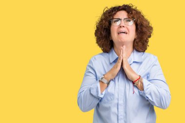 Güzel orta ager üst düzey businees kadın yalvarıyor ve umut ifade yüzünde çok duygusal ve endişe ile birlikte elleriyle dua izole arka plan üzerinde gözlük takıyorum. Bağışlanmak. Din kavramı.