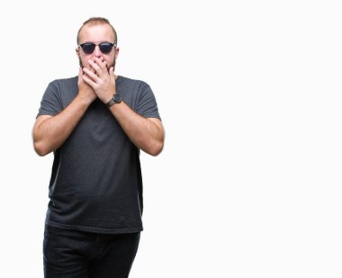 Üzerinde güneş gözlüğü takmış Genç beyaz hipster adam arka plan ağız hata için elleriyle kapsayan şok izole. Gizli kavramı.