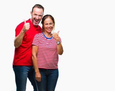 Orta yaş İspanyol çift hareketi el ile mutlu yaşasın yapıyor izole arka plan üzerinde aşık. Kameraya bakarak başarı gösteren ile ifade onaylama.