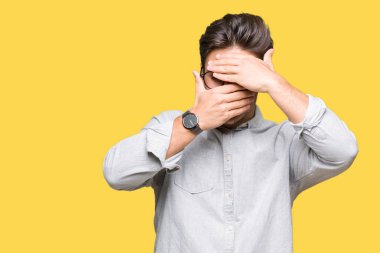 Yakışıklı delikanlı izole arka plan kaplaması gözler ve ağız el ile üzerinden gözlük takan şaşırttı ve şok. Duygu gizleme