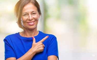 Orta yaş izole arka neşeli bir gülümseme ile el ve parmak kadar kameraya bakarak yüzündeki mutlu ve doğal ifade ile yan ile işaret yüz üzerinden İspanyol kadın kıdemli.