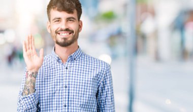 Genç yakışıklı iş adamı izole arka plan Waiving mutlu selam söyleyerek üzerinde ve gülümseyen, dostça karşılama jest