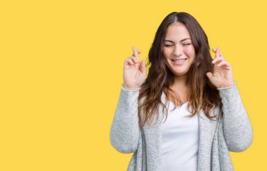 Güzel izole arka plan üzerinde kış ceket giyen boyutu genç kadın artı geçiş parmakları umut ve gözler gülümseyen kapalı. Şans ve batıl kavramı.