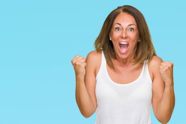 İzole arka plan kutlama üzerinde rahat yetişkin kadın güzel orta yaş şaşırttı ve başarı için kaldırdı kollarını açarak hayret ve gözleri açık. Kazanan kavramı.