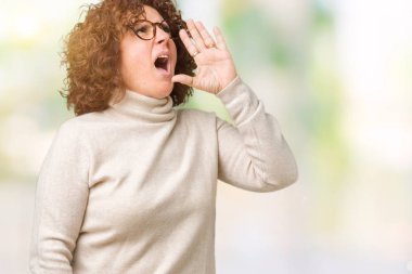 Boğazlı kazak ve gözlük bağırarak ve ağzı üzerinde el ile yan için çığlık izole arka plan üzerinde giyen güzel orta ager üst düzey kadın. İletişim kavramı.