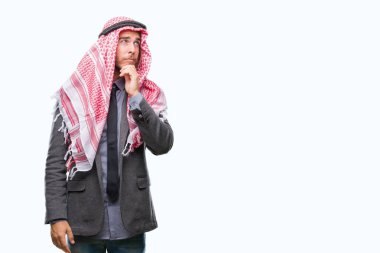 Genç yakışıklı Arap adam uzun saçlı çene düşünme hakkında soru, dalgın ifade üzerine el ile izole arka plan üzerinde keffiyeh giyiyor. Düşünceli yüzüyle gülümsüyor. Şüphe kavramı.