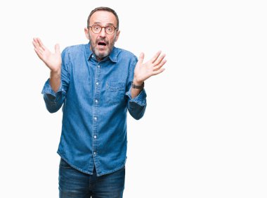 İzole arka plan clueless ve şaşkın bir ifadeyle kollar ve eller kaldırdı üzerinde gözlük takan orta yaş ağarmış komuta sizde. Şüphe kavramı.