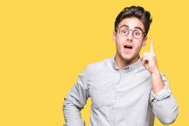 Başarılı fikirle izole arka plan işaret parmağı üzerinde gözlük takan yakışıklı delikanlı. Çıktıktan ve mutlu. Bir numara.