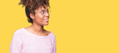 Uzak tarafına yüzünde, doğal ifade gülümseme ile seyir izole arka plan üzerinde gözlük güzel genç Afro-Amerikan kadın. Kendine güvenen gülüyor.