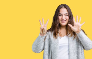 Parmakları ile sekiz kendinden emin ve mutlu gülümseyerek sırasında gösterilen ve yukarı dönük izole arka plan üzerinde kış ceket giyen boyutu genç kadın artı güzel numara.