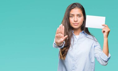 Açık eliyle dur işareti ile ciddi ve kendine güvenen ifade, savunma jest yapıyor izole arka plan üzerinde boş kartı tutan genç Arap kadın