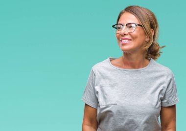 Arka plan uzak tarafına gülümseme ile yüzünde, doğal ifade seyir üzerinde gözlük takan orta yaş İspanyol kadın kıdemli izole. Kendine güvenen gülüyor.