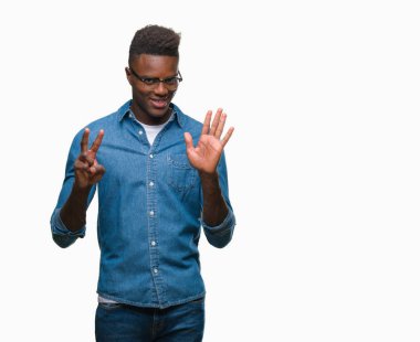 Gösterilen ve parmakları ile işaret izole arka plan üzerinde genç Afro-Amerikan adam kendinden emin ve mutlu gülümseyerek süre yedi numara.