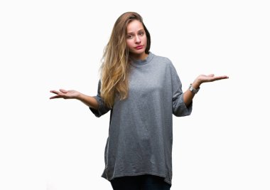 Genç güzel sarışın kadın izole arka plan clueless ve şaşkın bir ifadeyle kollar ve eller kaldırdı. Şüphe kavramı.