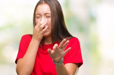 Genç güzel beyaz bir kadın bir şey pis ve iğrenç kokulu izole arka plan, dayanılmaz koku, holding nefes burun parmaklar ile. Kötü kokuyor kavramı.