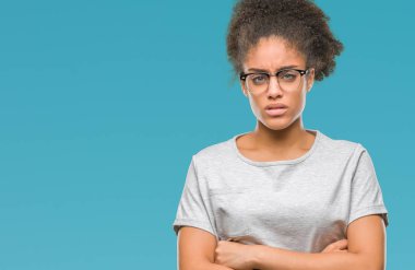 İzole arka plan şüpheci ve çapraz kolları olan yüzündeki gergin, onaylamayan ifade gözlüklü genç afro Amerikalı kadın. Negatif kişi.
