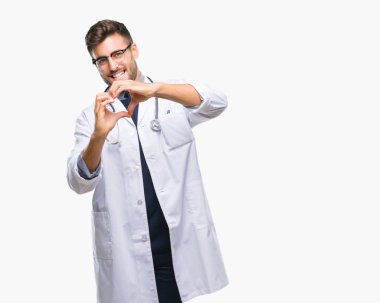 Genç yakışıklı Doktor adam aşık kalp simgesi ve elleriyle şekil gösteren gülümseyen izole arka plan üzerinde. Romantik kavramı.