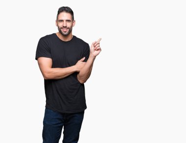 Kameraya bakarak yan el ve parmak ile işaret eden genç yakışıklı adam yüzünde kocaman bir gülümseme ile izole arka plan üzerinde.
