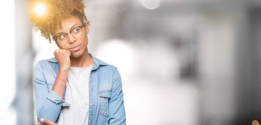 Güzel genç Afro-Amerikan kadın gözlük ile izole arka plan üzerinde çene düşünme hakkında soru, dalgın ifade ver. Düşünceli yüzüyle gülümsüyor. Şüphe kavramı.