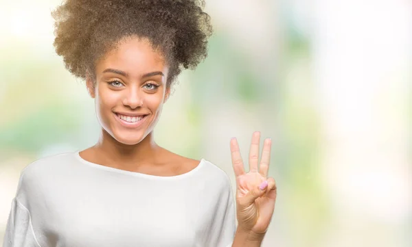 Young afro american woman over isolated background showing and pointing up with fingers number three while smiling confident and happy.