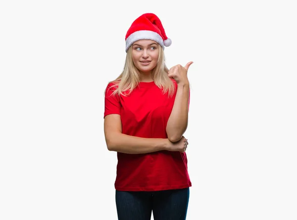 年轻的白种人妇女戴着圣诞节帽子在孤立的背景微笑与快乐的脸看和指向侧与拇指向上 — 图库照片