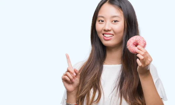 Young Asian Woman Eating Donut Isolated Background Surprised Idea Question — Stock Photo, Image