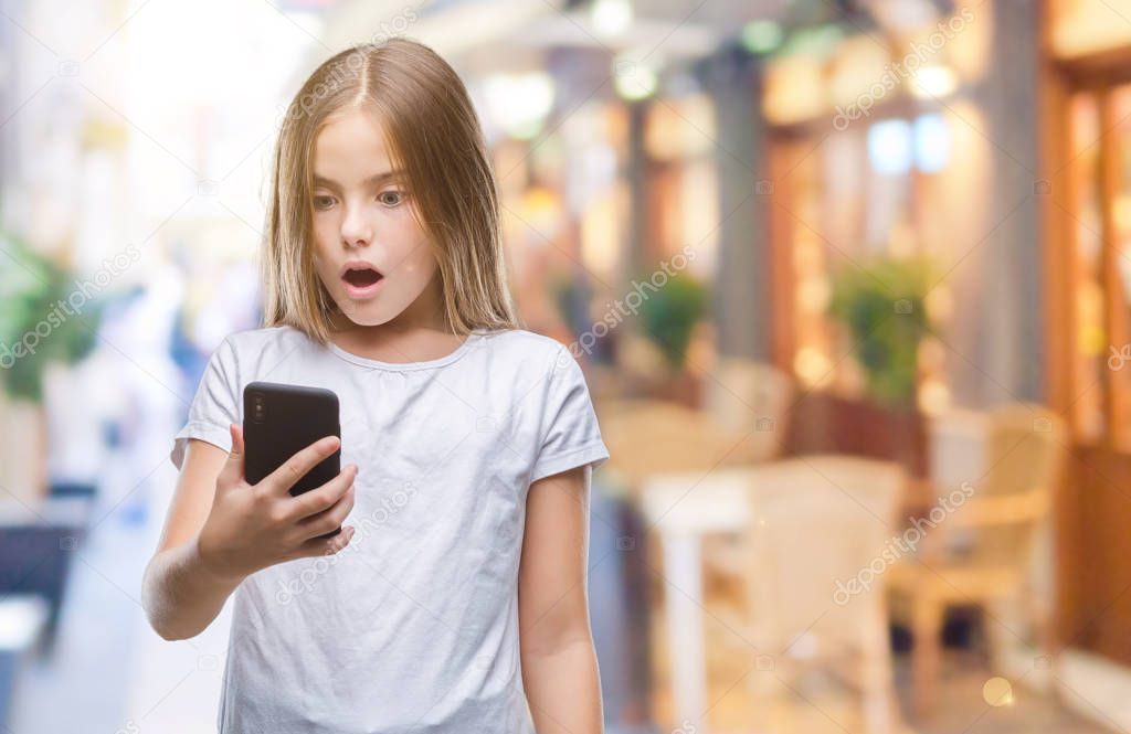 Young beautiful girl sending message texting using smarpthone over isolated background scared in shock with a surprise face, afraid and excited with fear expression