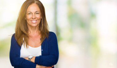 İzole arka plan mutlu yüz çapraz silah kameraya bakarak ile gülümseyen güzel orta yaş rahat yetişkin kadın. Olumlu bir kişi.