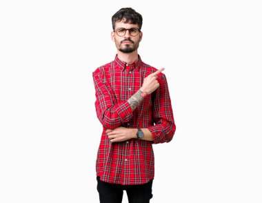 Genç yakışıklı adam gözlük izole üzerinde işaretçi el parmak reklam, ciddi ve sakin yüz gösterilen yan için arka plan