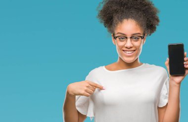 Genç güzel afro Amerikan gösteren smartphone ekran kendisi için sürpriz yüz işaret parmağı ile izole arka plan üzerinde