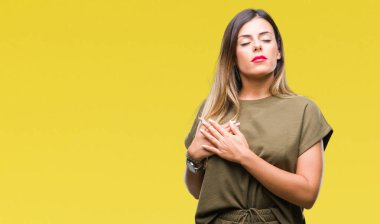 Genç güzel kadın ile gülümseyen izole arka plan yüzünden kapalı gözler ve yüzünde minnettar jest ile göğüs üzerinde eller. Sağlık kavramı.