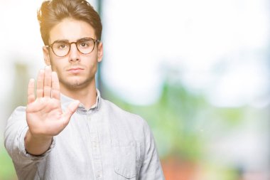 Genç yakışıklı elin avuç durağı şarkı yapıyor izole arka plan üzerinde gözlük adam. Negatif ve ciddi bir jest yüz ifadesiyle uyarı.