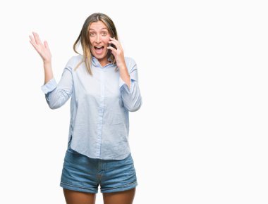 Genç güzel kadın smartphone üzerinde kocaman bir gülümseme ile çığlık zaferini kutluyor ve ellerini kaldırdı izole arka plan çok mutlu ve heyecanlı, kazanan ifade söz