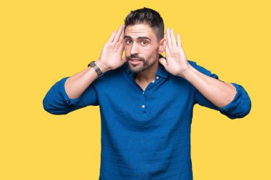 Yakışıklı delikanlı kulak jest, dedikodu için meraklı her iki ellerde dinliyoruz izole arka plan üzerinde. İşitme sorunu, sağır