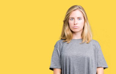 Çatık izole arka plan şüpheci ve gergin, büyük boy rahat t-shirt giyen güzel genç kadın sorunu nedeniyle üzgün. Negatif kişi.