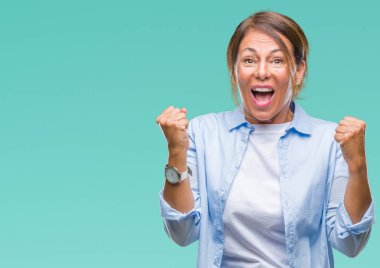 İzole arka plan kutlama üzerinde orta yaş İspanyol kadın kıdemli şaşırttı ve başarı için kaldırdı kollarını açarak hayret ve gözleri açık. Kazanan kavramı.