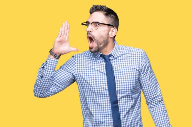 Bağırarak ve ağzı üzerinde el ile yan için çığlık izole arka plan üzerinde gözlük takan genç iş adamı. İletişim kavramı.