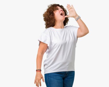 İzole arka plan 2shouting üzerinde beyaz t-shirt giyen ve ağzı üzerinde el ile yan için çığlık güzel orta ager üst düzey kadın. İletişim kavramı.