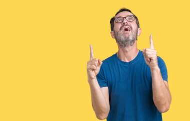 İzole arka plan üzerinde gözlük nedir yakışıklı orta yaş ağarmış komuta sizde hayrete ve yukarıya bakıyor ve parmakları ile işaret ve silah kaldırdı şaşırttı.