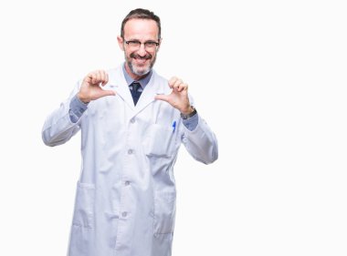 Orta yaş üst düzey ağarmış profesyonel adam yüzünde gülümseme ile kendinden emin görünüyorsun, kendini gururlu ve mutlu parmakları ile işaret izole arka plan üzerinde beyaz önlük giyiyor.