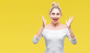 Genç güzel sarışın ve mavi gözlü kadın deli kutluyor arka plan izole ve başarı için kaldırdı kollarını açarak hayrete ve heyecanlı çığlık gözleri açık. Kazanan kavramı