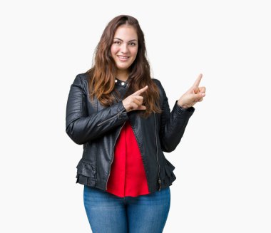 Artı boyutu genç kadın güzel üzerinde bir moda deri ceket giyiyor gülümseyen ve iki elleri ve parmakları ile tarafına işaret kamera bakarak arka plan izole.