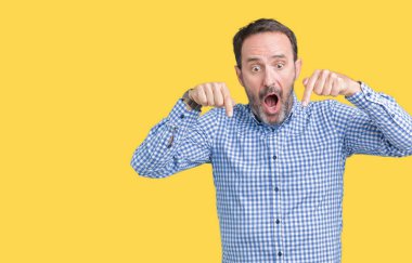 Yakışıklı orta yaş zarif komuta sizde izole üzerinde arka plan işaretleme aşağı reklam, sürpriz yüz ve açık ağız gösterilen parmakları ile