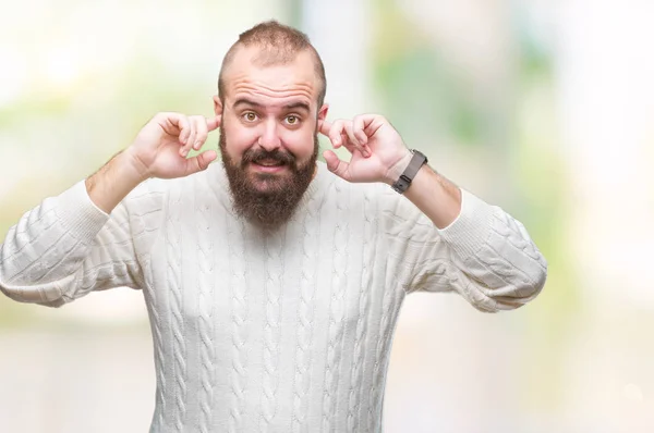 年轻的高加索嬉皮士男子穿着冬季毛衣在孤立的背景覆盖耳朵与手指与愤怒的表达为响亮的音乐的噪音 聋哑人的概念 — 图库照片